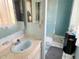 Compact blue bathroom with a tiled shower, sink, and toilet at 7345 E Hinsdale Pl, Centennial, CO 80112