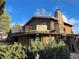 Exterior view of stone and wood home featuring a wraparound balcony and spiral staircase at 7345 E Hinsdale Pl, Centennial, CO 80112