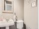 A half bathroom with pedestal sink, toilet, and neutral paint at 7388 S Lafayette W Cir, Centennial, CO 80122