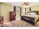 Spacious bedroom with a ceiling fan, dresser, and large window providing natural light at 7388 S Lafayette W Cir, Centennial, CO 80122