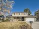 Charming two-story home features a brick facade, swing, well-manicured lawn, and attached two car garage at 7388 S Lafayette W Cir, Centennial, CO 80122