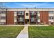 Two-story brick apartment building with black iron balconies, walkway, and green lawn at 5995 W Hampden Ave # 3I, Denver, CO 80227