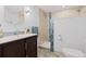 Modern bathroom with mosaic-tiled shower and dark wood vanity features ample lighting at 9604 Brentwood Way # B, Broomfield, CO 80021