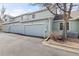 Light blue townhome with three-car garage and landscaped yard, showcasing curb appeal at 9604 Brentwood Way # B, Broomfield, CO 80021