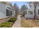 A cozy sideyard with a concrete pathway, neat landscaping, and charming architectural details between homes at 9604 Brentwood Way # B, Broomfield, CO 80021