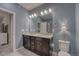 Bathroom featuring a double sink vanity, ample lighting, and a view of the shower at 24806 E Calhoun Pl # A, Aurora, CO 80016