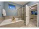 Modern bathroom with a soaking tub, tiled surround, and glass-enclosed shower at 24806 E Calhoun Pl # A, Aurora, CO 80016