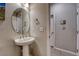 Small pedestal sink bathroom with large round mirror and adjacent doorway at 24806 E Calhoun Pl # A, Aurora, CO 80016