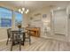 The dining area has hardwood floors, a modern chandelier, a round table, large windows, and a piano at 24806 E Calhoun Pl # A, Aurora, CO 80016