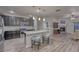 This open kitchen has grey cabinets, stainless appliances, a spacious island with seating, and hardwood floors at 24806 E Calhoun Pl # A, Aurora, CO 80016