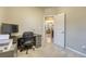Home office with gray carpet, gray walls, large monitor, printer and doorway to kitchen at 24806 E Calhoun Pl # A, Aurora, CO 80016