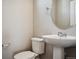 Clean bathroom with pedestal sink and oval mirror at 6860 Merseyside Ln, Castle Pines, CO 80108