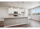 Modern kitchen with white cabinets, granite countertops, and an island at 6860 Merseyside Ln, Castle Pines, CO 80108