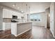 Modern kitchen with white cabinets, granite countertops, and an island at 6860 Merseyside Ln, Castle Pines, CO 80108