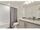 This full bathroom has a shower over tub, gray vanity with granite counters, and a decorative mirror at 4478 Riviera Ct, Aurora, CO 80019