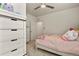 This bright bedroom has a ceiling fan, neutral carpet, and large dresser for storage at 4478 Riviera Ct, Aurora, CO 80019