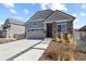 Inviting home featuring stone detailing, a two-car garage, and a landscaped front yard at 4478 Riviera Ct, Aurora, CO 80019