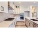 Bright kitchen boasts white cabinets, stainless steel appliances, a gas range, and a quartz island at 11453 Autumn Moon St, Littleton, CO 80125