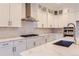 Modern kitchen features white cabinets, stainless steel appliances, quartz countertops, and a stylish backsplash at 11453 Autumn Moon St, Littleton, CO 80125