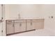 Functional laundry area features modern cabinetry, a sink, and neutral tile flooring at 11453 Autumn Moon St, Littleton, CO 80125