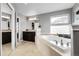 Bathroom featuring a deep soaking tub with tile surround, and dark wood vanity at 3266 Coyote Hills Way, Castle Rock, CO 80109