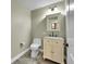 Well-lit powder room featuring a cream-colored vanity with storage, granite countertop, and a decorative mirror at 300 W 11Th Ave # 8C, Denver, CO 80204