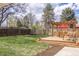 Backyard featuring a deck with a pergola, a lounge area with Adirondack chairs, and a well-maintained lawn at 4825 S Delaware St, Englewood, CO 80110