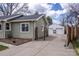 Exterior view of the house showcasing a long driveway leading to a detached garage with two garage doors at 4825 S Delaware St, Englewood, CO 80110