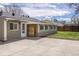 Backyard exterior featuring a sunroom with lots of windows, siding, and a concrete patio at 4825 S Delaware St, Englewood, CO 80110