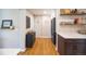Bright hallway with modern black refrigerator, floating shelves, and warm wood flooring at 4825 S Delaware St, Englewood, CO 80110
