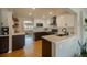 Gorgeous kitchen with modern appliances, two-tone cabinets, floating shelves and quartz countertops at 4825 S Delaware St, Englewood, CO 80110