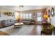 Bright living room featuring hardwood floors, neutral-colored furniture, and a large window with shutter blinds at 4825 S Delaware St, Englewood, CO 80110
