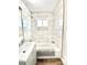 Clean bathroom with white marble-patterned tile, tub-shower, and modern vanity at 7901 Newport St, Commerce City, CO 80022
