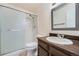 This bathroom offers a sink with wood cabinets, a shower, and a mirror at 16036 E Ithaca Pl # E, Aurora, CO 80013