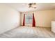 This bedroom offers neutral walls and carpeting, a ceiling fan, and red curtains at 16036 E Ithaca Pl # E, Aurora, CO 80013