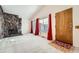 Bright living room with a stone fireplace, vaulted ceilings, neutral walls and carpeting, plus red curtains and wood front door at 16036 E Ithaca Pl # E, Aurora, CO 80013