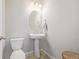 Small bathroom featuring a pedestal sink, an oval mirror and a toilet at 11400 W Grand Ave, Littleton, CO 80127