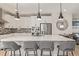 Modern kitchen featuring white cabinets, stainless steel appliances, a mosaic backsplash, and a large center island at 11400 W Grand Ave, Littleton, CO 80127