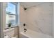 Modern bathroom with a bathtub, shower, and marble tile at 2222 Fenton St, Edgewater, CO 80214