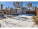 Back of house with deck and gate, snowy yard at 2222 Fenton St, Edgewater, CO 80214