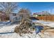 Back exterior view of the house with deck and snowy yard at 2222 Fenton St, Edgewater, CO 80214