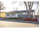 Ranch style home with gray siding, updated landscaping, and a spacious front yard at 5341 Granby St, Denver, CO 80239