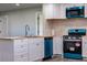 Modern kitchen with white cabinets, teal appliances, and wood-look flooring at 5341 Granby St, Denver, CO 80239