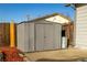 Backyard view featuring the modern grey metal shed on a concrete slab, offering extra storage at 5341 Granby St, Denver, CO 80239