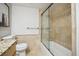 Tiled bathroom boasts a shower-tub combo with glass door and granite vanity at 1250 N Humboldt St # 1504, Denver, CO 80218