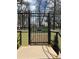View of the secure Embassy House gate with manicured landscaping and mature trees at 1250 N Humboldt St # 1504, Denver, CO 80218