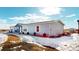 Gray manufactured home with white trim and snowy landscaping at 43620 E 80Th Ave, Bennett, CO 80102