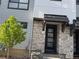 Modern townhome entrance with stone accents, black trim, and a welcoming front door at 2066 S Holly St # 3, Denver, CO 80222