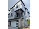 Modern townhome exterior featuring light blue siding, stone accents, and a private balcony at 2066 S Holly St # 3, Denver, CO 80222