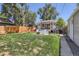 Beautiful backyard with a covered patio, fire pit area, and lush green lawn at 3975 S Logan St, Englewood, CO 80113